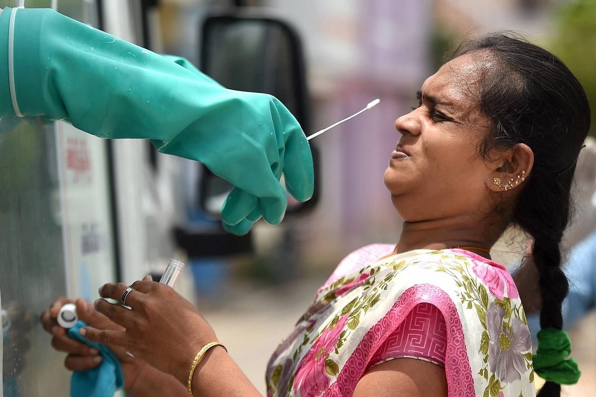 A woman reacts as a medic collects samples for Covid-19 swab testing, at a medical camp in Chennai, Monday, June 29, 2020. Credit: PTI Photo