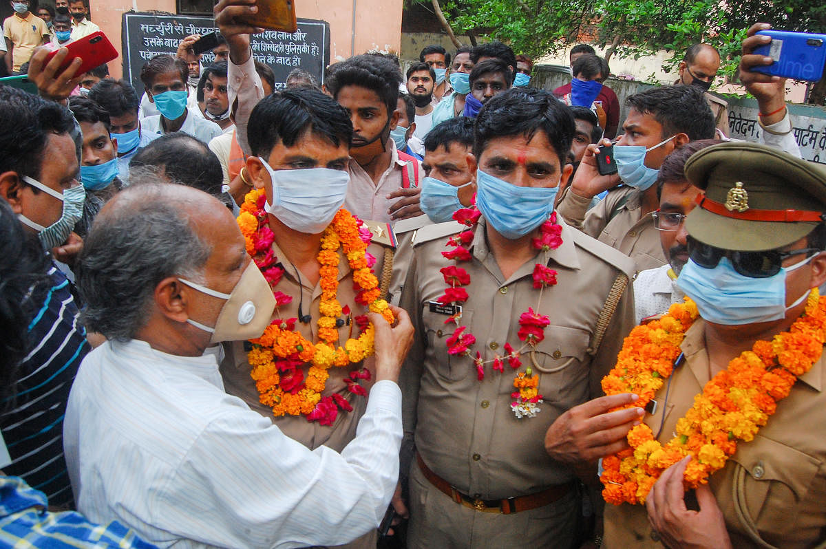 Social workers garland policemen for killing of gangster Vikas Dubey, outside the mortuary at the Lala Lajpat Rai Hospital in Kanpur. Credit: PTI