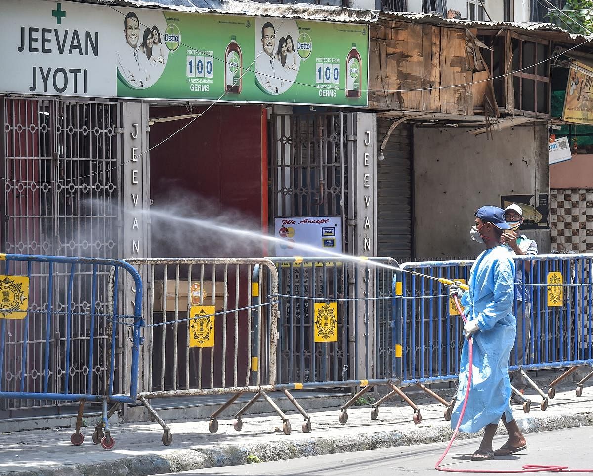  A municipal corporation worker sprays disinfectant at a sealed residential area following surge in Covid-19 cases, during Unlock 2.0 in Kolkata (PTI Photo)