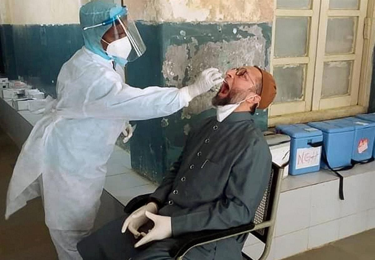A medic collects a sample of AIMIM President Asaduddin Owaisi for Covid-19 test, at Nizamia Tibbi Hospital in Hyderabad. Credit: PTI Photo
