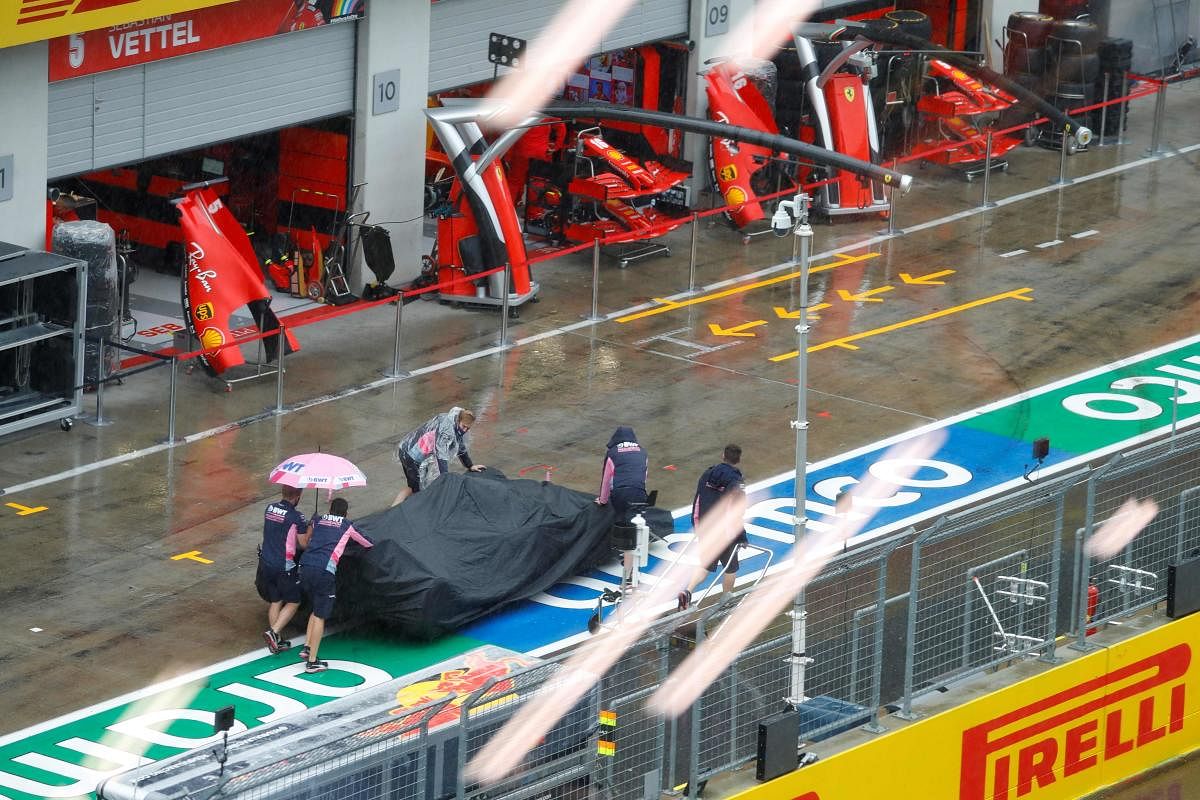 Racing Point's staff push a car after the third practice session for the Formula One Styrian Grand Prix has been cancelled due to heavy rain in Spielberg, Austria. Credit: AFP Photo