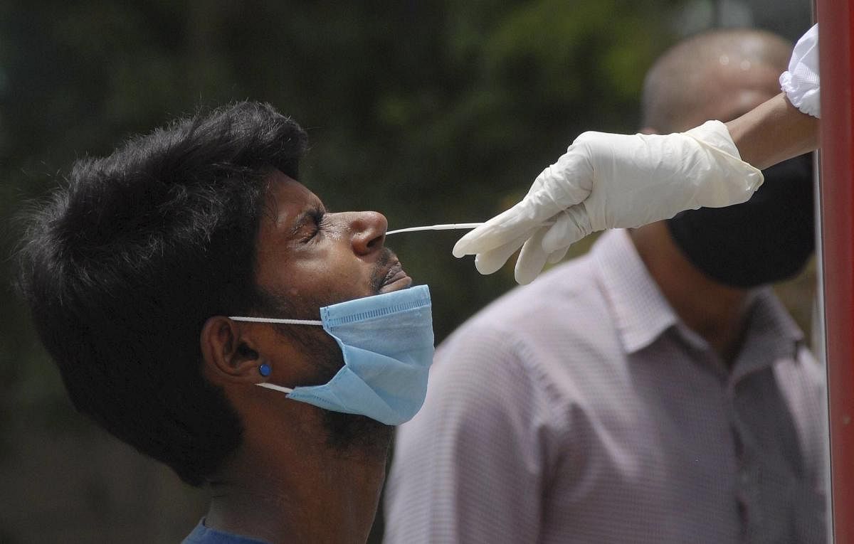 A medic takes sample from a person for Covid-19 test, at a hospital in Noida, Friday, June 19, 2020. Credit: PTI Photo