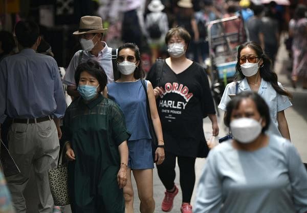 Pedestrians wearing face masks walk through a market in central Seoul. Credit: AFP