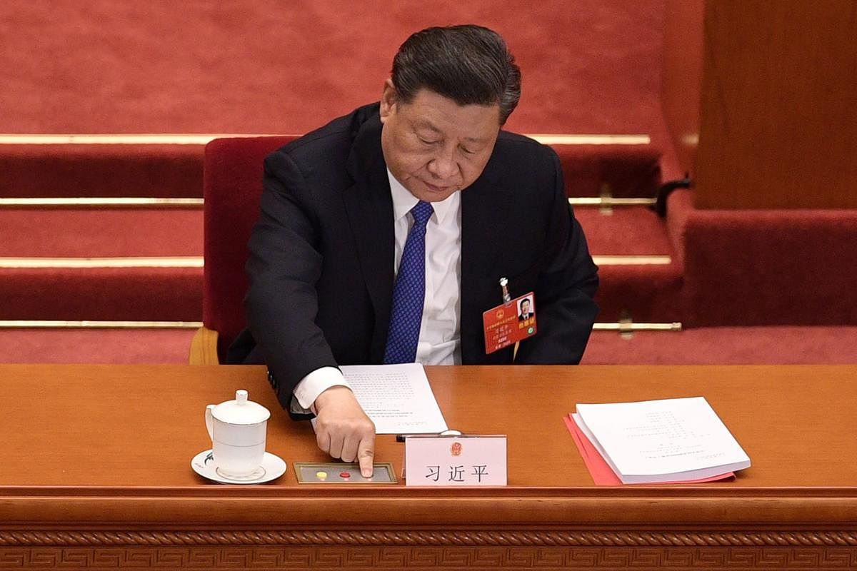 (FILES) This file photo taken on May 28, 2020 shows China's President Xi Jinping voting on a proposal to draft a security law on Hong Kong during the closing session of the National People's Congress at the Great Hall of the People in Beijing. - China pas
