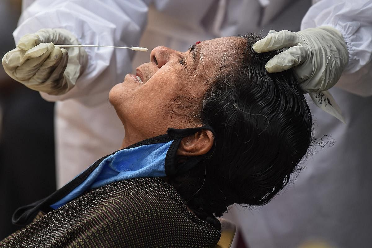  A health worker collects a sample of a woman for Covid-19 test at a medical camp, during Unlock 2.0, in Chennai (PTI Photo)