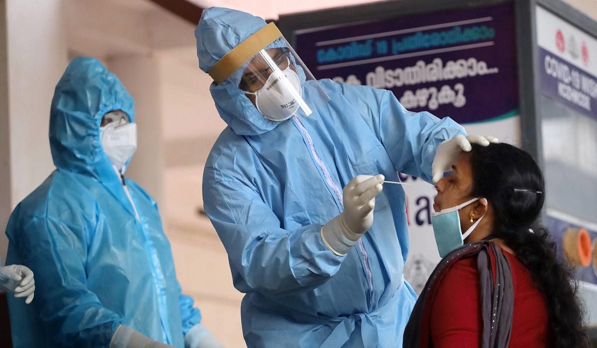  Health workers collect swab sample from a woman for Covid-19 tests, in Kozhikode, Thursday, July 9, 2020. Credit: PTI Photo