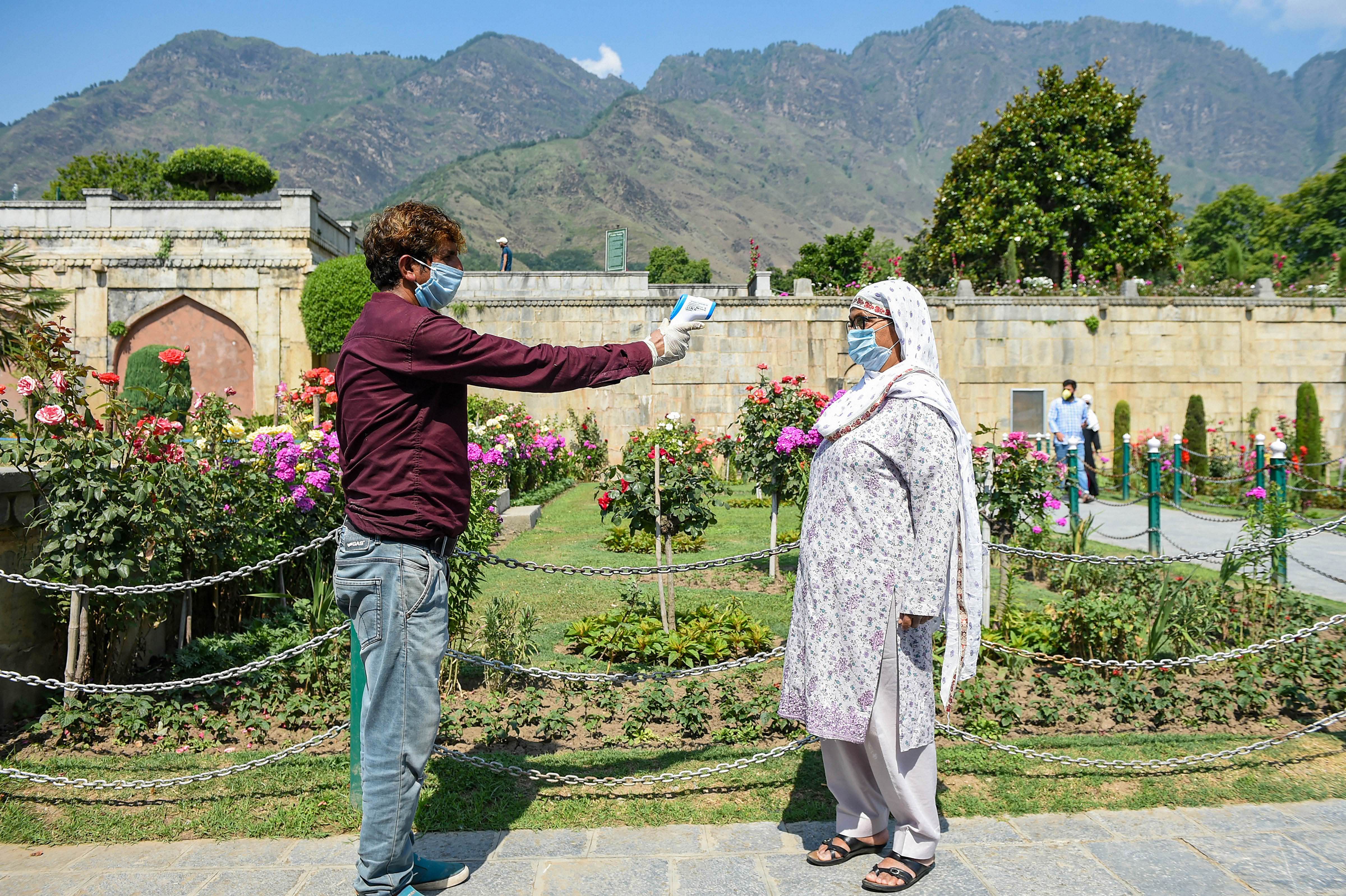 A visitor undergoes thermal screening at the entrance of Mughal garden after the authorities decided to reopen it for tourists, during Unlock 2.0, in Srinagar. Credits: PTI Photo