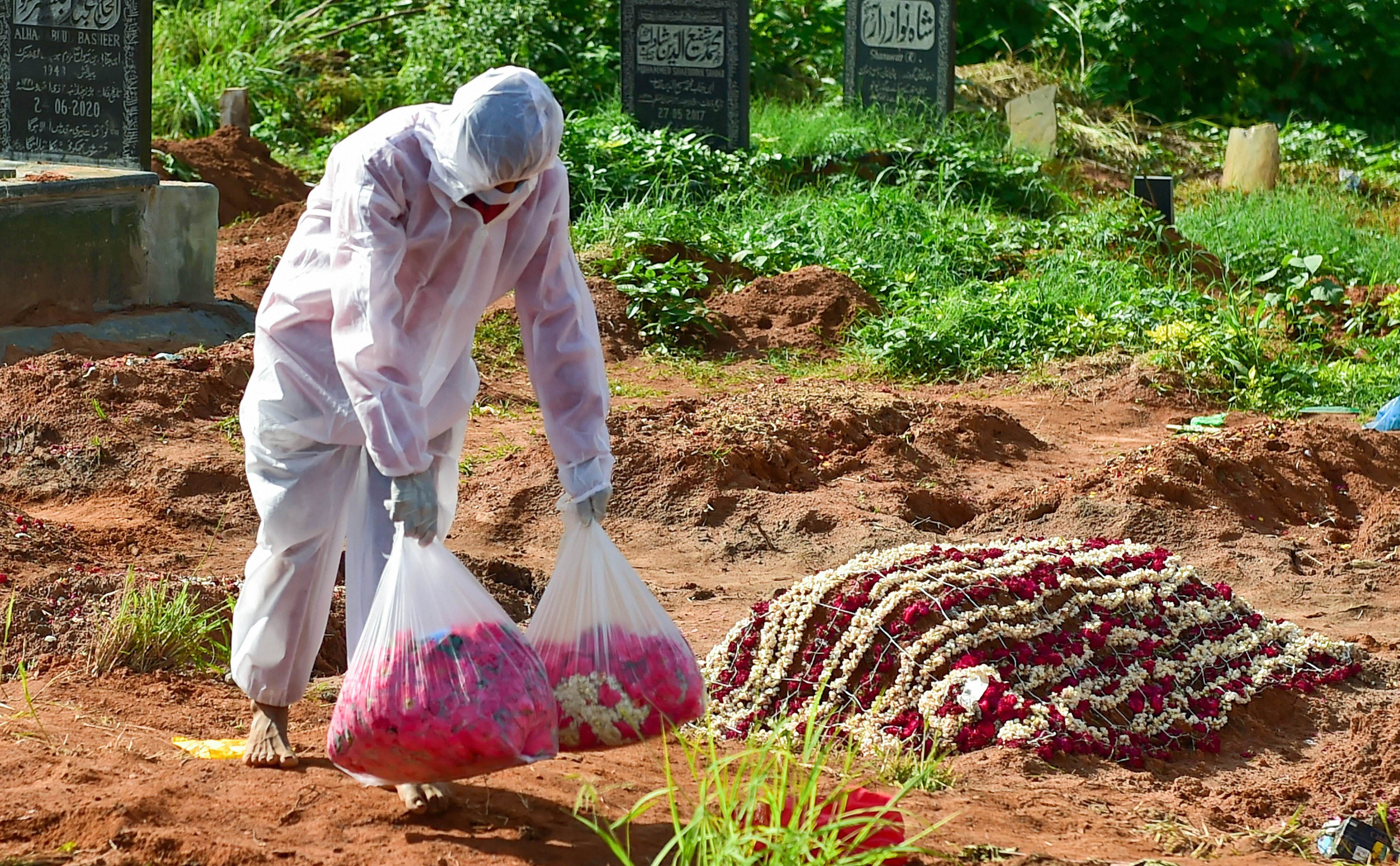Volunteers from Mercy Angel and their helping hand team perform the last rites of a Covid-19 victim. Credits: PTI Photo