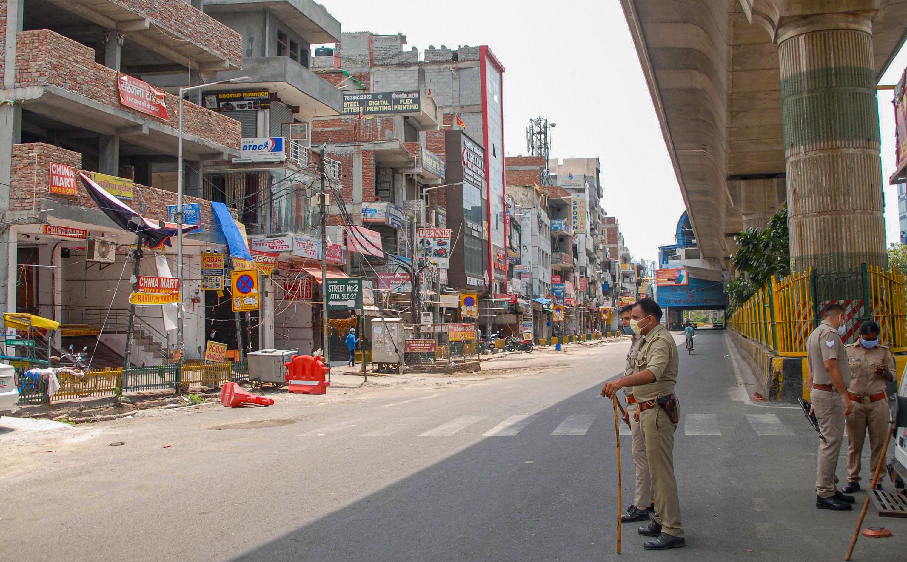 Police stand guard during a 55 hour intensified lockdown to curb the spread of coronavirus disease, in Noida, Saturday, July 11, 2020. (PTI Photo)