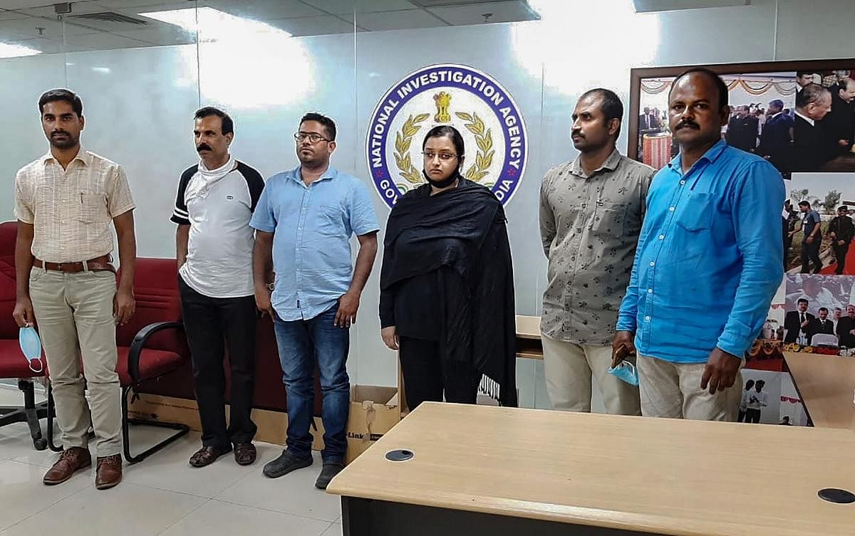 Kerala gold smuggling case accused Swapna Suresh and Sandeep Nair (both in middle) after they were arrested by the National Investigation Agency in Bengaluru. Credit: PTI