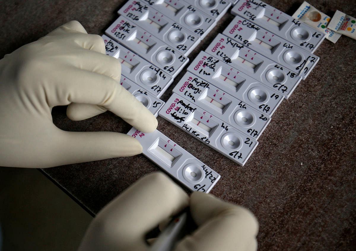 A healthcare worker writes the date on a rapid antigen detection testing kit after collecting swab from residents during a check-up campaign to tackle the coronavirus disease outbreak in Ahmedabad, India, July 6, 2020. Credit: Reuters Photo