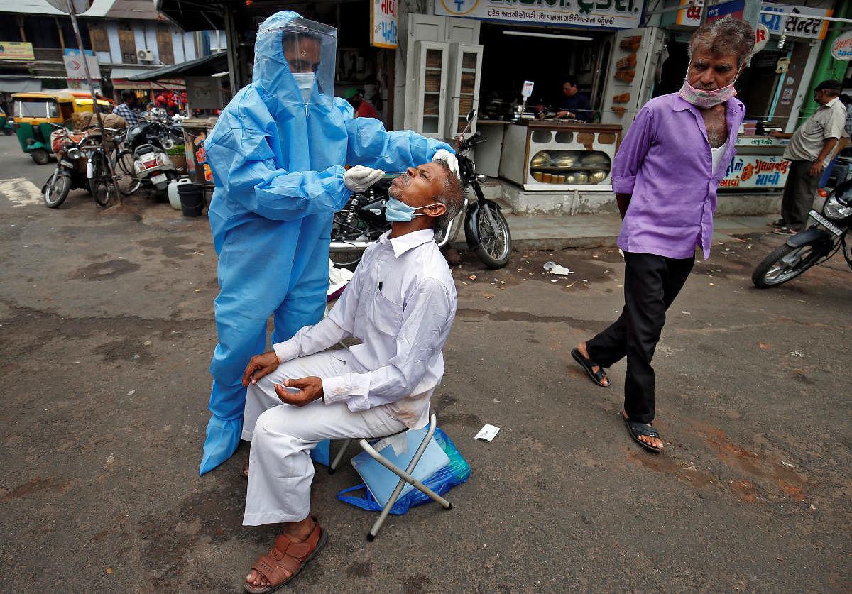 A healthcare worker takes a swab from a man in Ahmedabad.Credit:  Reuters file photo