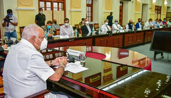 Karnataka Chief Minister B S Yediyurappa chairs a meeting with experts and senior officers to discuss ways forward in Covid-19 management, in Bengaluru. Credit: PTI Photo