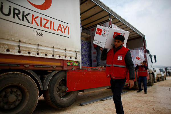 Turkish Red Crescent workers carry humanitarian aid at Kelbit camp, near the Syrian-Turkish border, in Idlib province, Syria. Credit: Reuters Photo