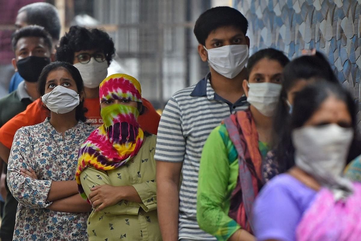 Residents stand in a queue as they wait for their turn to get screened during a medical screening for the COVID-19 coronavirus, at a residential society in Mumbai on July 10, 2020. Credit: AFP Photo