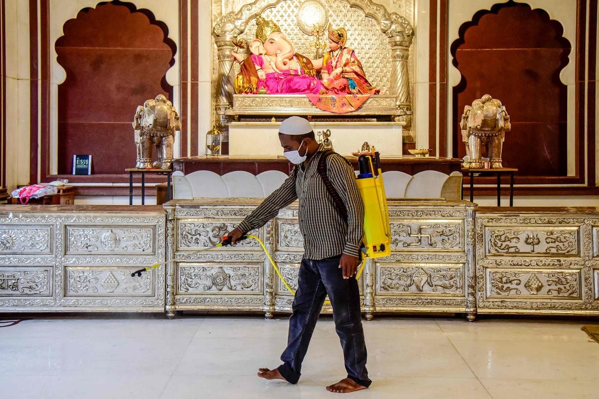 A member from Ummat social organisation sprays disinfectant in the Sharada Ganapati Mandai hindu temple, as religious places prepare to re-open amid the COVID-19 coronavirus outbreak, in Pune on June 25, 2020. Credit: AFP Photo