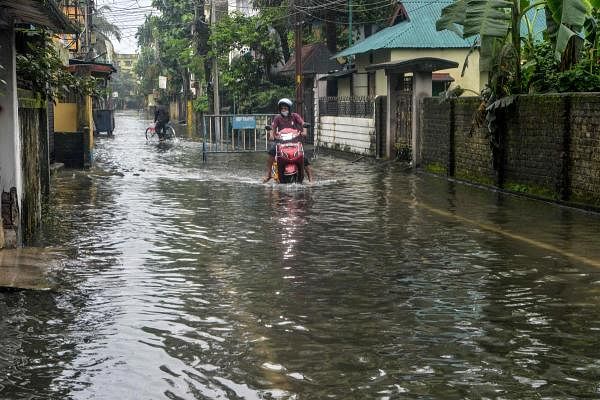 A motorist makes his way on a flooded street during heavy rain showers in Siliguri on July 11, 2020. Credit: AFP Photo