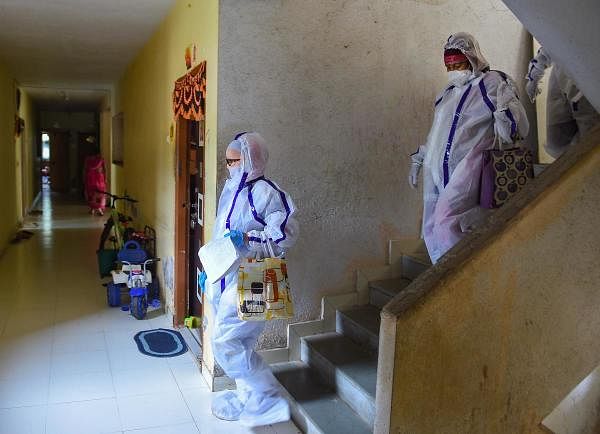Health officials inspect a coronavirus-infected area. Credit: PTI
