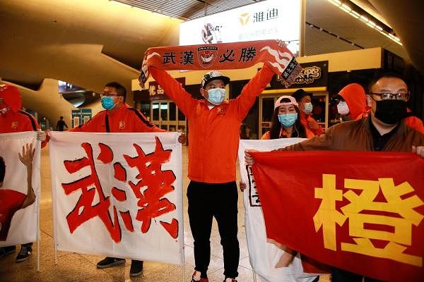 Fans of the Wuhan Zall football team welcoming the team members. Credit: AFP
