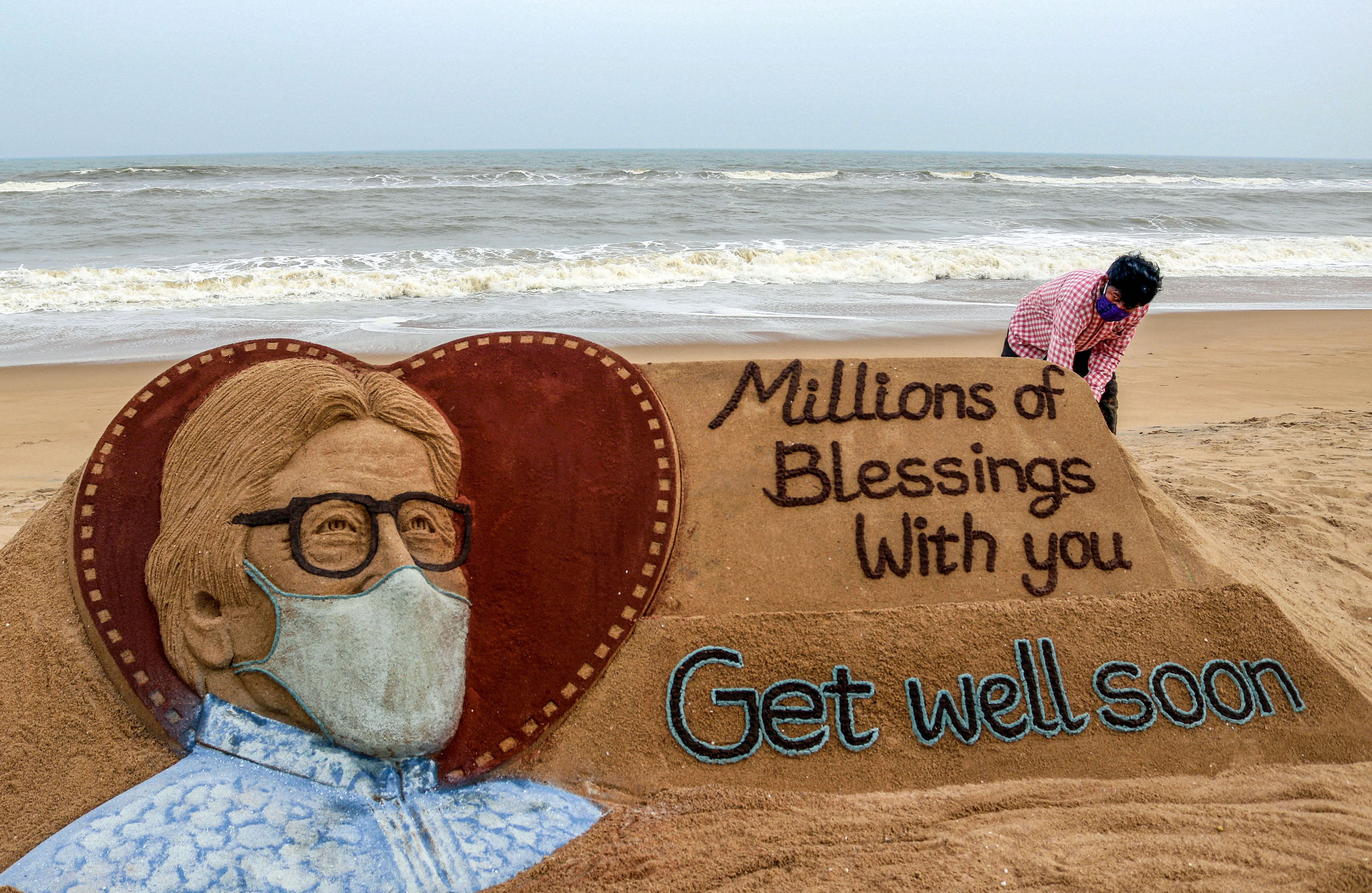 Sand artist Sudarsan Pattnaik gives a final touch to a sand sculpture of Bollywood actor Amitabh Bachchan for his speedy recovery from Covid-19, at Puri beach, Sunday, July 12, 2020. (PTI Photo)