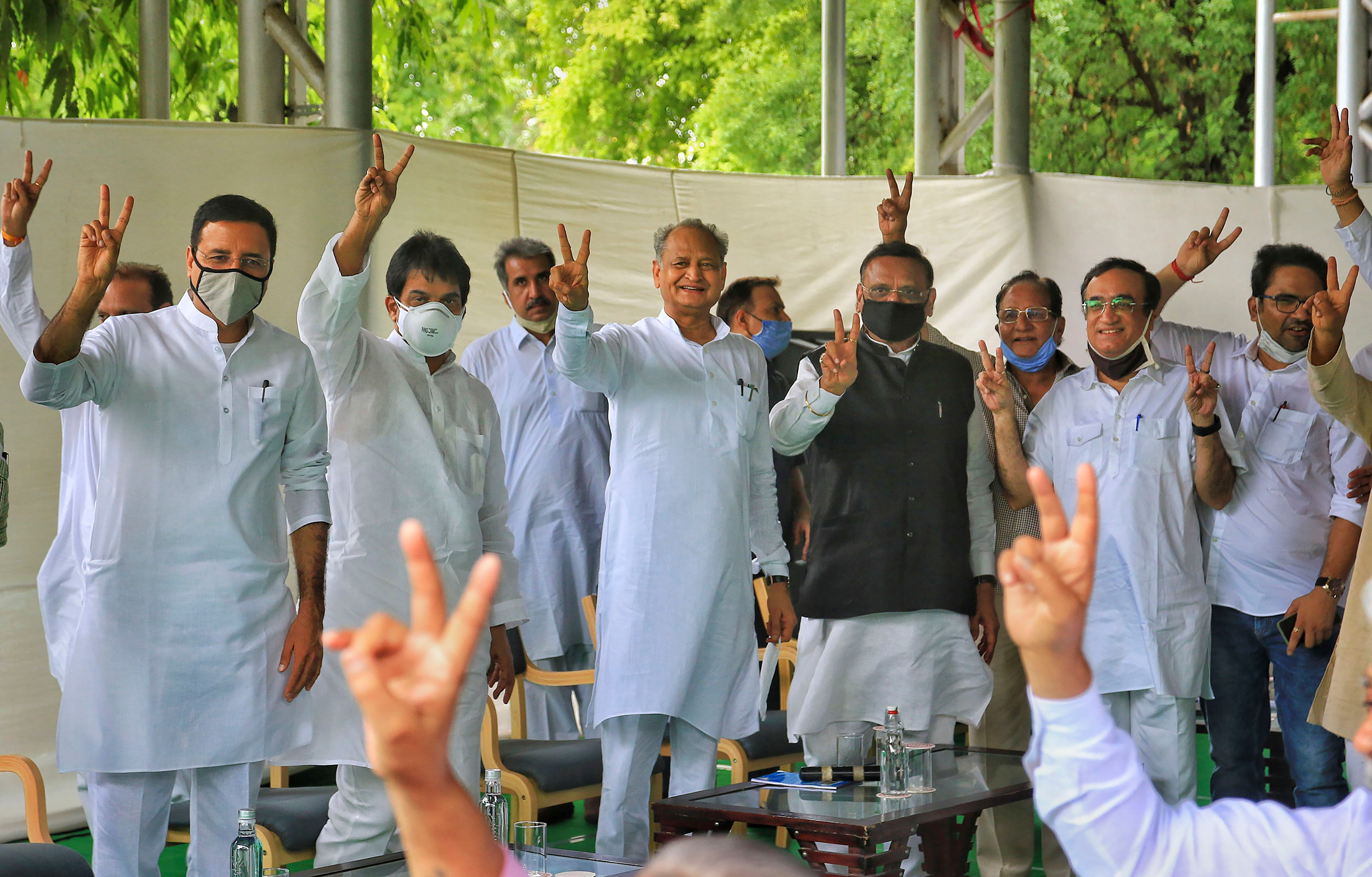 Rajasthan Chief Minister Ashok Gehlot (C) with senior Congress leaders Randeep Surjewala, Avinash Pandey, Ajay Maken and K.C. Venugopal flashes victory sign during a meeting with the party MLAs at his residence in Jaipur. Credits: PTI Photo