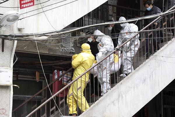 Health officials carry a Covid-19 infected body. Credit: AP