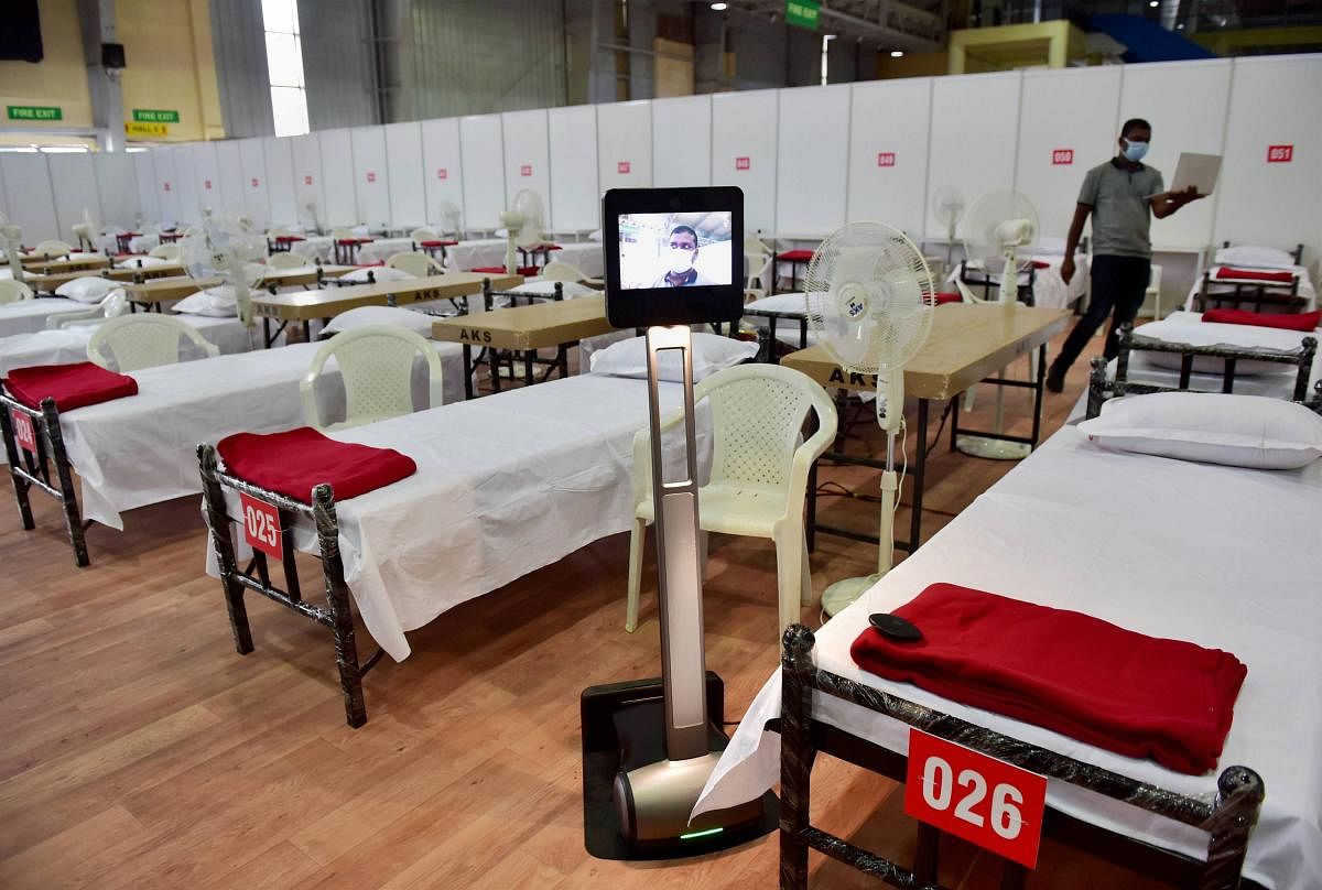 A robot, which will be used by doctors to monitor patients remotely, is seen near a bed inside a temporary COVID-19 care centre, at Bengaluru International Exhibition Centre (BIEC) in Bengaluru, Thursday, July 9, 2020. Credit: PTI Photo