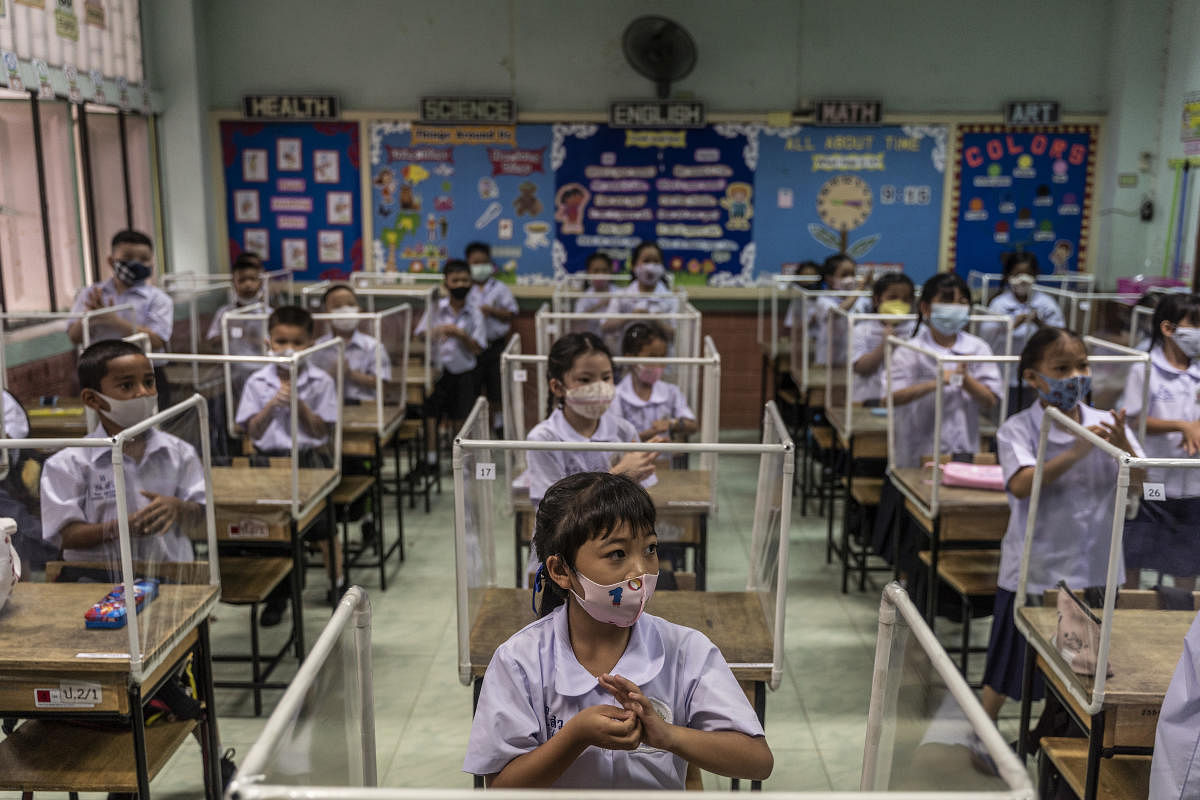 Returning students discuss handwashing protocols on the first day back at Sawasdee Wittaya Primary School in Bangkok, July 1, 2020. The New York Times