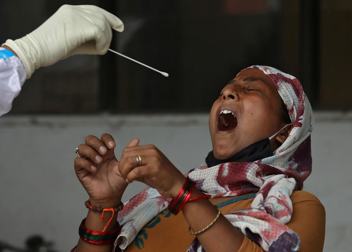 A woman reacts as a healthcare worker takes a swab from her to test for the coronavirus disease in Kolkata, India July 10, 2020. Credit: Reuters Photo