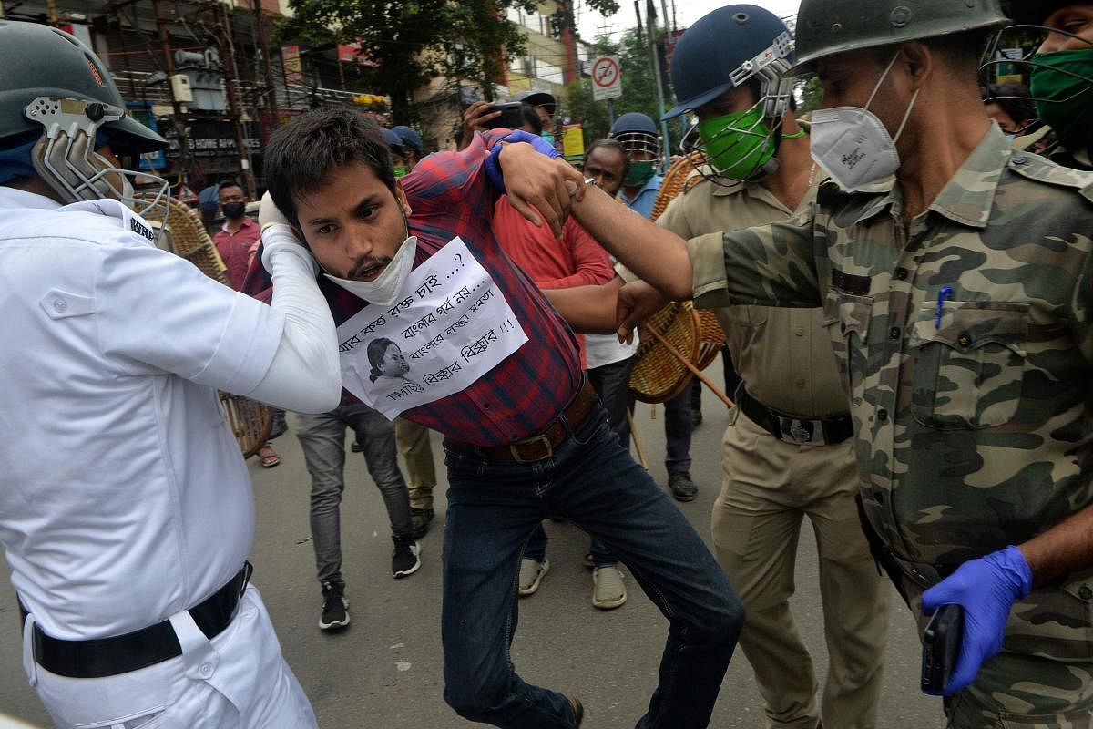 Police personnel clash with activists of Bharatiya Janata Party (BJP) as they shout slogans and protest during a strike demanding the Central Bureau of Investigation (CBI) for an investigation over the death of BJP MLA Debendra Nath Roy in Hemtabad, in Siliguri. Credit: PTI Photo