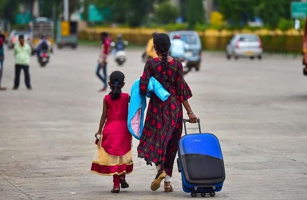People wait for means of transportation as they leave the city after authorities announced one week lockdown due to surge in Covid-19 cases, in Bengaluru, Monday, July 13, 2020. Credit: PTI Photo