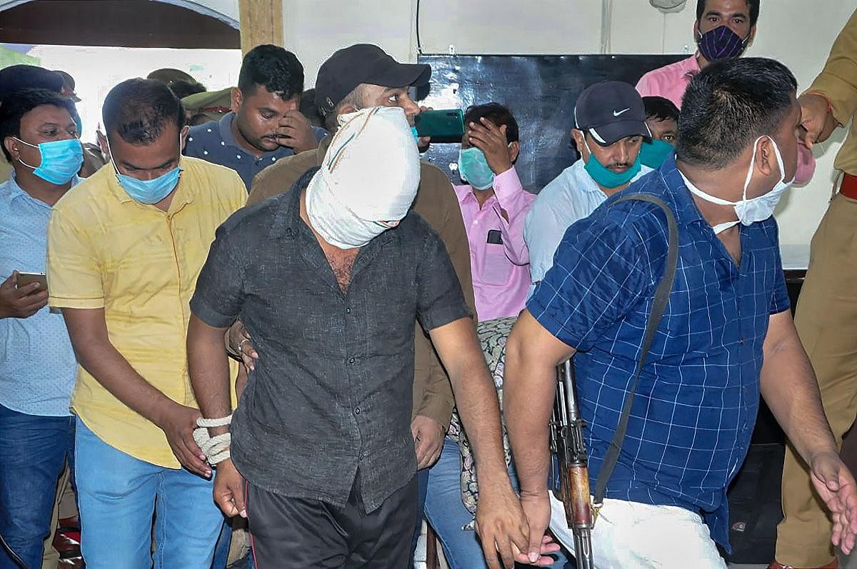 Police escort gangster Vikas Dubey's aide Shashikant Pandey who was arrested from Chaubepur, in Kanpur. Credit: PTI Photo