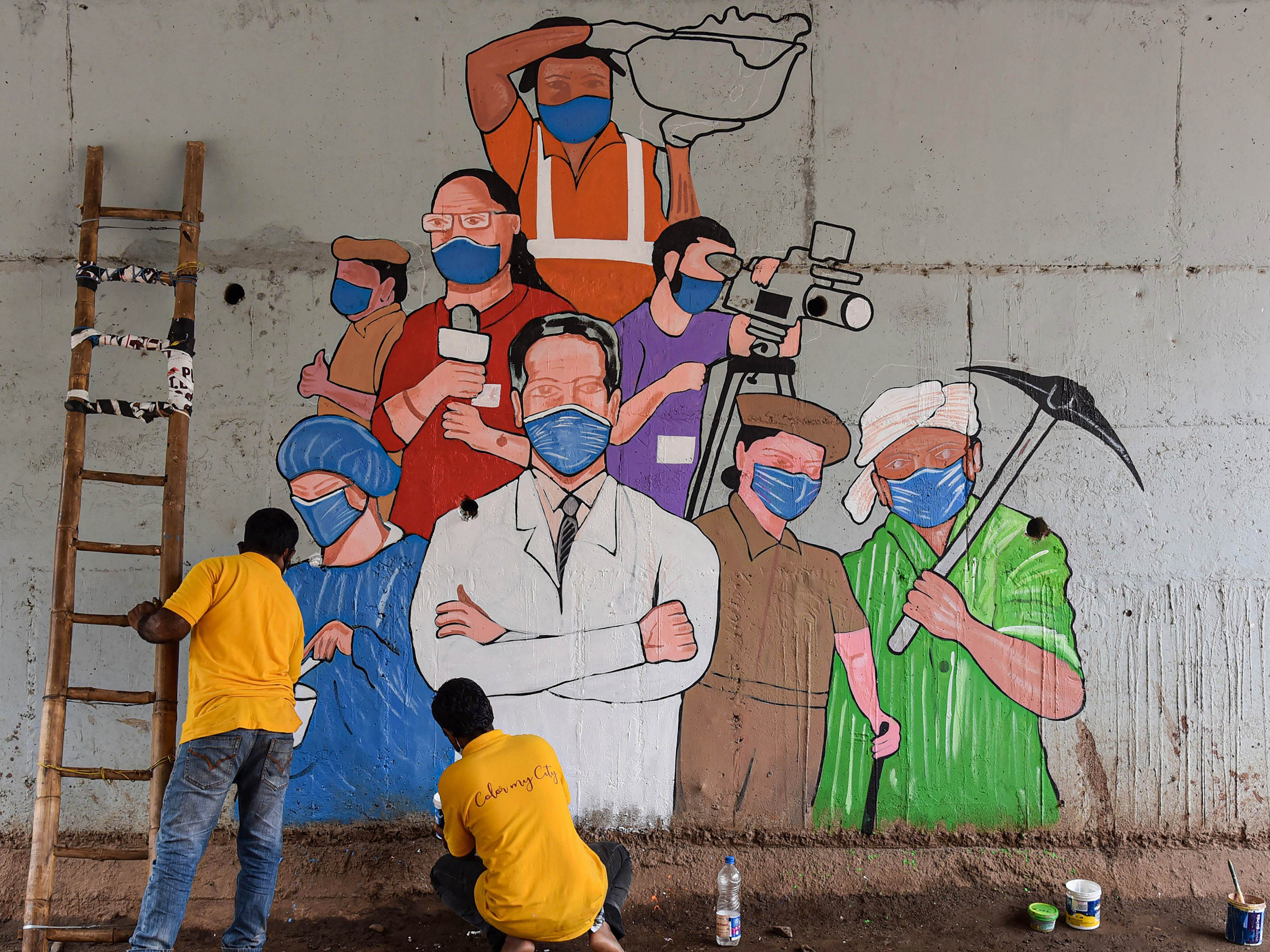 Artists paint a mural on COVID-19 frontline workers in Hubballi. Credit: PTI