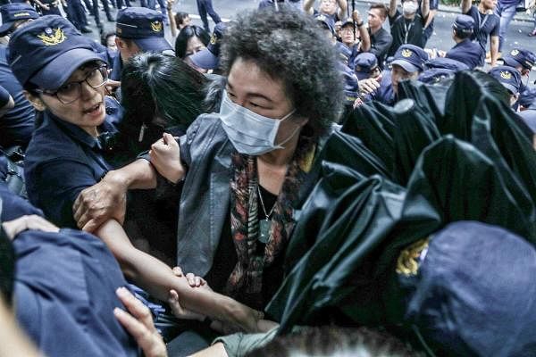 Chen Chu (C), former secretary general of the presidential office, being helped by police to get into the parliament after Taiwan's President Tsai Ing-wen nominated her as chairwoman of the country’s watchdog body in Taipei. Credit: AFP Photo