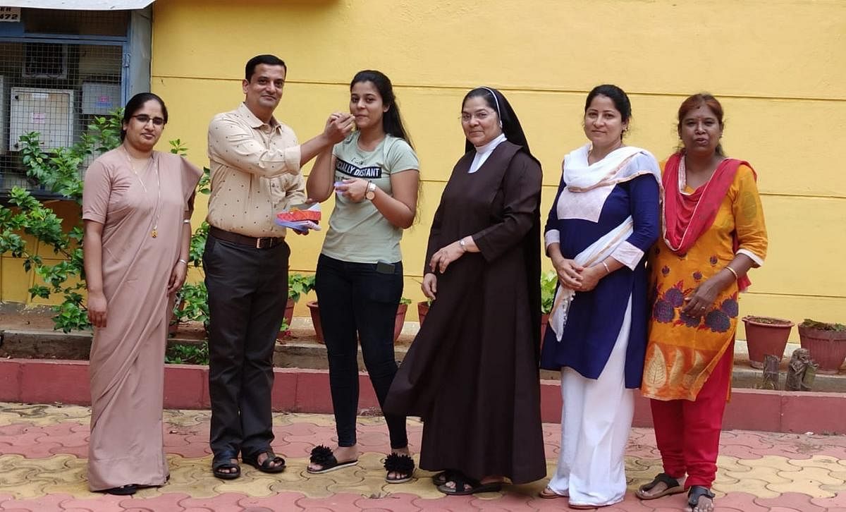 Commerce topper H Vidhi, who has secured 97.5%, seen with faculty members of Carmel’s II PU College in Mandya on Tuesday. DH PHOTO