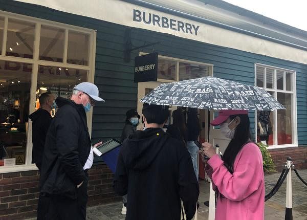 Shoppers are seen queuing outside the Burberry shop. Credit: Reuters