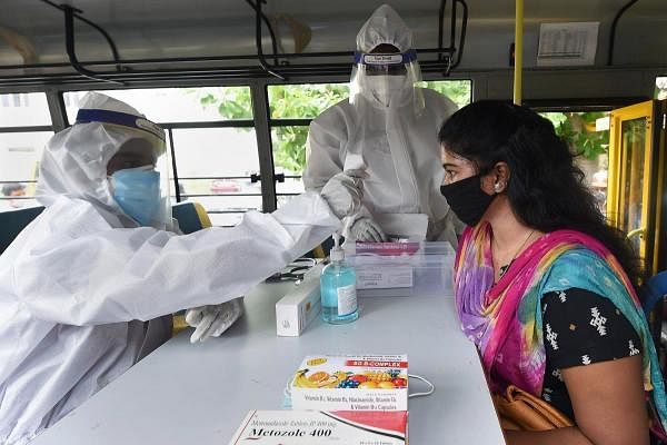 A health worker wearing PPE checks temperature of a girl at a mobile dispensary, during Unlock 2.0, in Chennai, Wednesday, July 15, 2020. Credit: PTI Photo