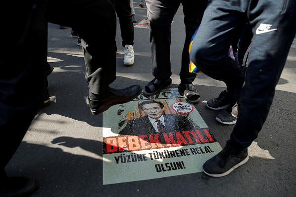 Ethnic Uighur demonstrators step on a poster with an image of Communist Party Secretary of Xinjiang Uighur Autonomous Region Chen Quanguo during a protest against China. Representative Photo. Credit: Reuters