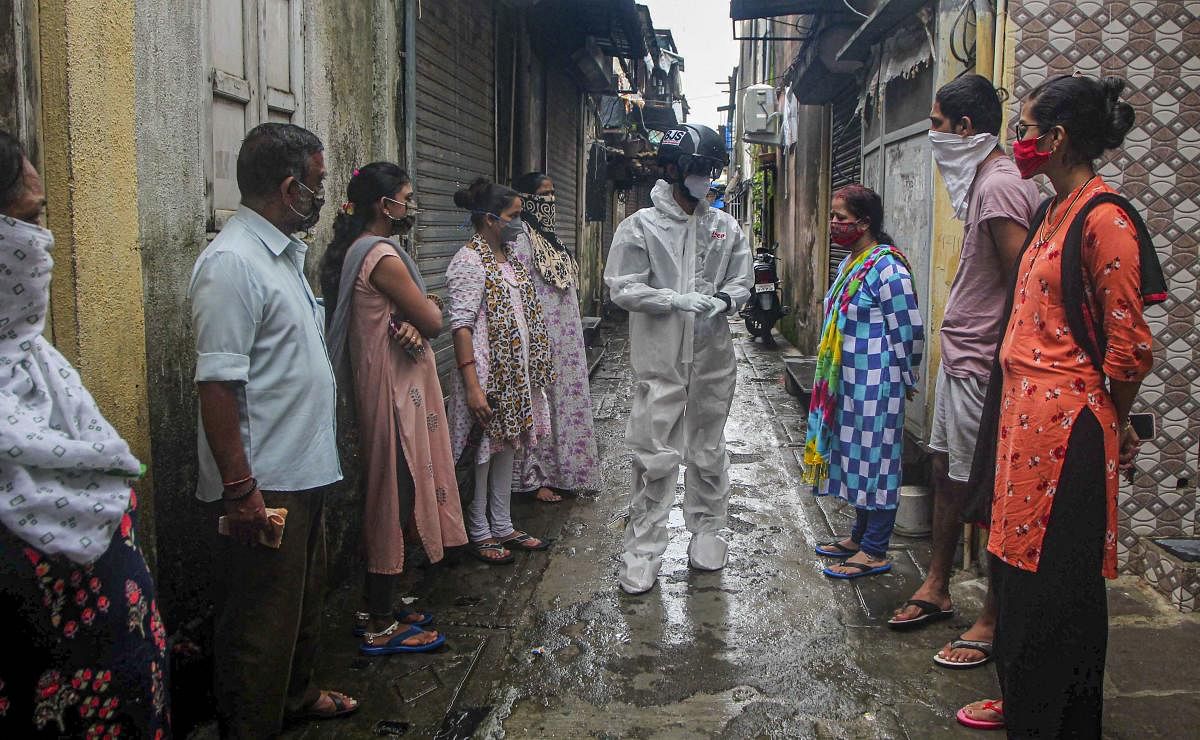 A medic wearing a PPE conducts thermal screening using a smart helmet, as coronavirus cases rise across the state, at Dahisar in Mumbai. Credit: PTI Photo