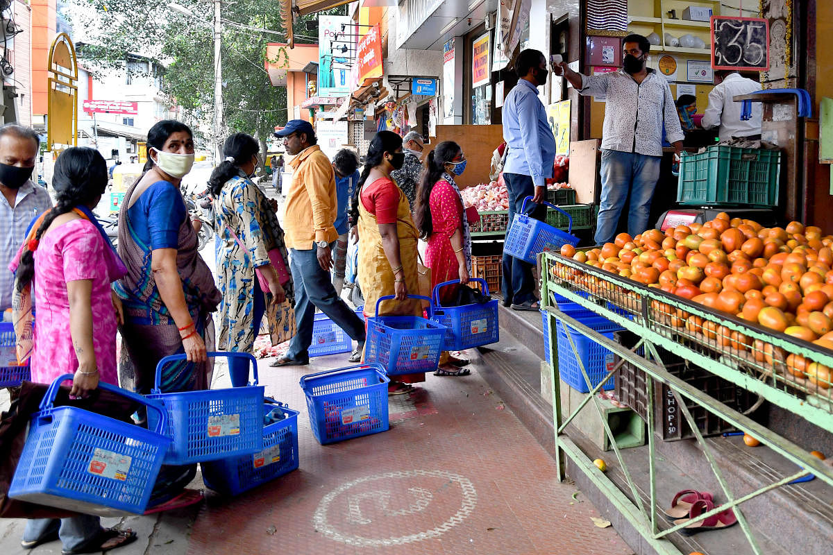 People line up to buy groceries at a store in Malleswaram ahead of the weeklong lockdown in Bengaluru on Tuesday. DH Photo/Pushkar V