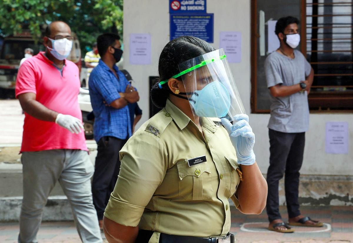 A policewoman wearing a face shield waits for Covid-19 testing, during Unlock 2.0, in Thiruvananthapuram, Saturday, July 11, 2020. Credit: PTI Photo