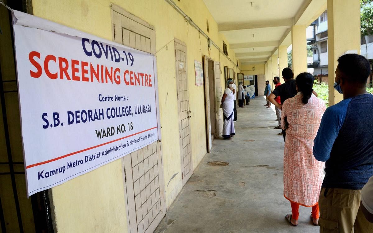  People stand in a queue as they wait for their turn to give swab samples for COVID-19 test, at a hospital in Guwahati, Saturday, July 4, 2020. Credit: PTI Photo