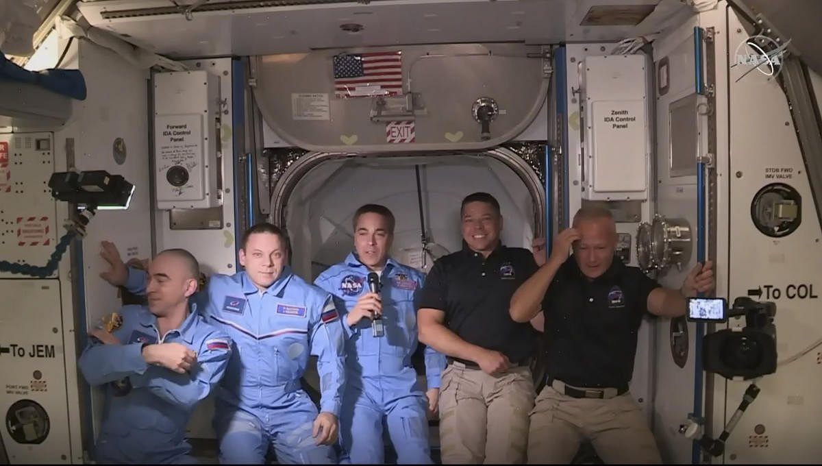 This NASA video frame grab image shows NASA SpaceX’s Crew Dragon astronauts Douglas Hurley(R) and Robert Behnken(2ndR) arriving after the hatch opened to the International Space Station posing with other astronauts on May 31, 2020. Credit: AFP Photo