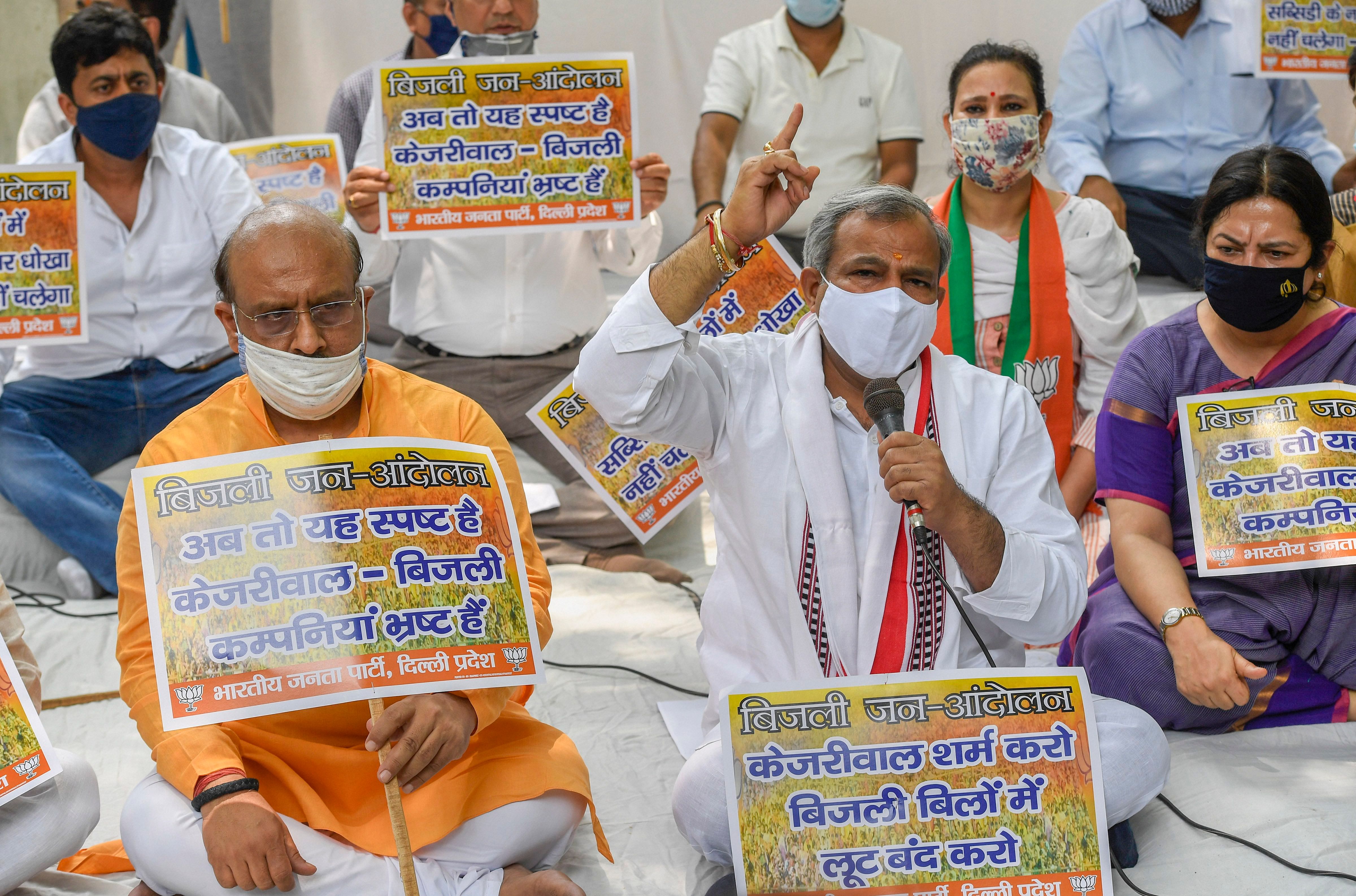 BJP Delhi President Adesh Gupta and senior leader Vijender Gupta display placards during a protest demonstration against the Arvind Kejriwal government, on the issue of allegedly inflated electricity bills, in Malviya Nagar in New Delhi. Credits: PTI Photo