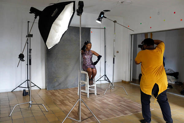 Photographer Alexander Ashimole is seen during a photoshoot with fashion model Reta Jerry-Riman as they create campaign images to contribute to the social media challenge called the 'Vogue Africa Challenge' at a studio in Lagos, Nigeria. Credit: Reuters Photo