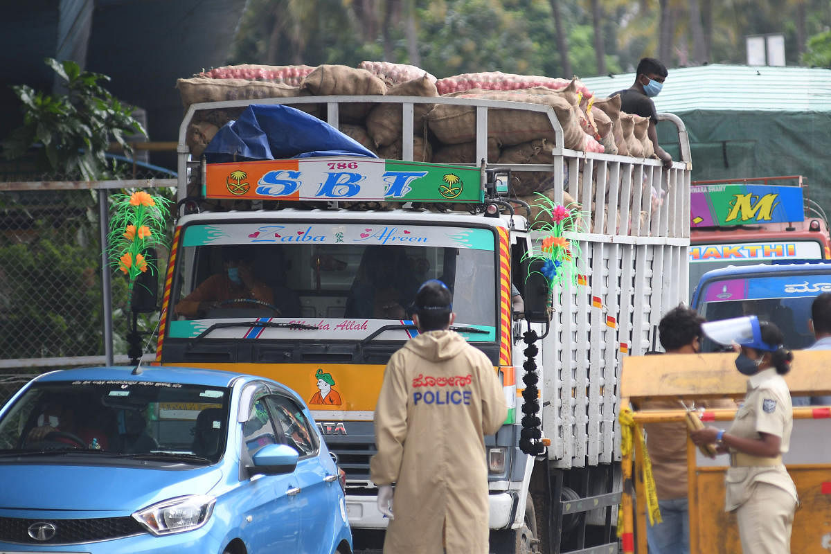 Police personnel and BBMP marshals check vehicles near Yeshwantpur on Thursday. DH Photo/Pushkar V