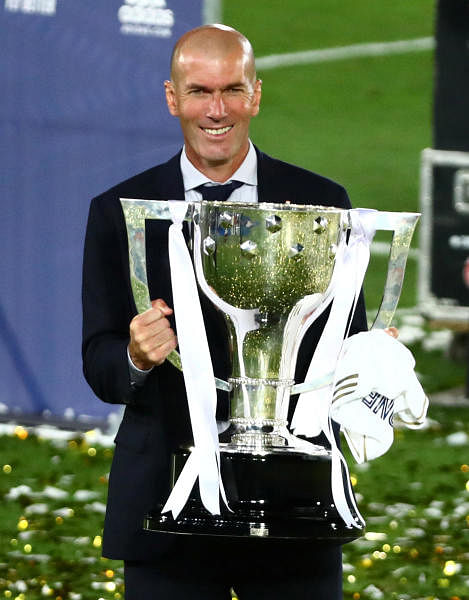Real Madrid coach Zinedine Zidane celebrates with the trophy after winning La Liga, as play resumes behind closed doors following the outbreak of the coronavirus disease. Credit: Reuters Photo