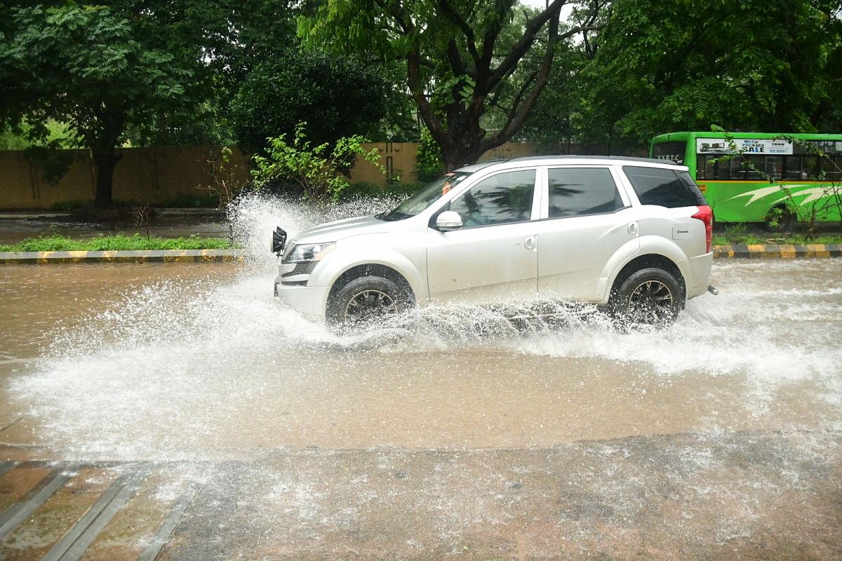 A car navigates the flooded road at Kottari in Mangaluru. Credit: DH