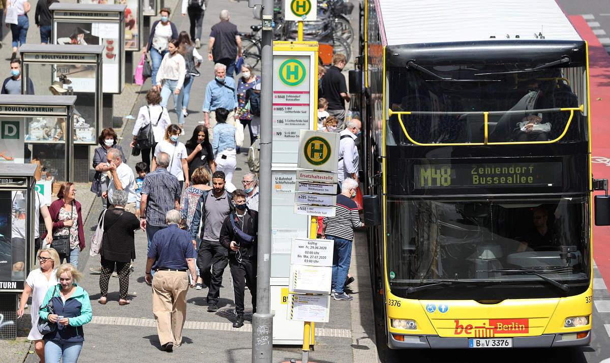 People are seen with and without wearing face masks at a public transport bus stop, following the coronavirus disease (COVID-19) outbreak in Berlin, Germany. Credit: REUTERS