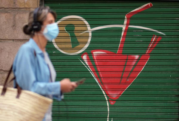 A woman wearing a face mask walks on a street, after Catalonia's regional authorities and the city council announced restrictions to contain the spread of the coronavirus. Credit: Reuters